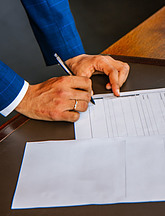 man signing documents